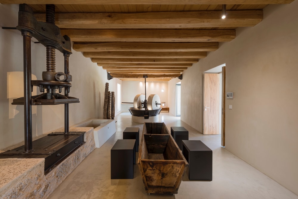 Rusted Mill House med møllestein og presse midt i rommet