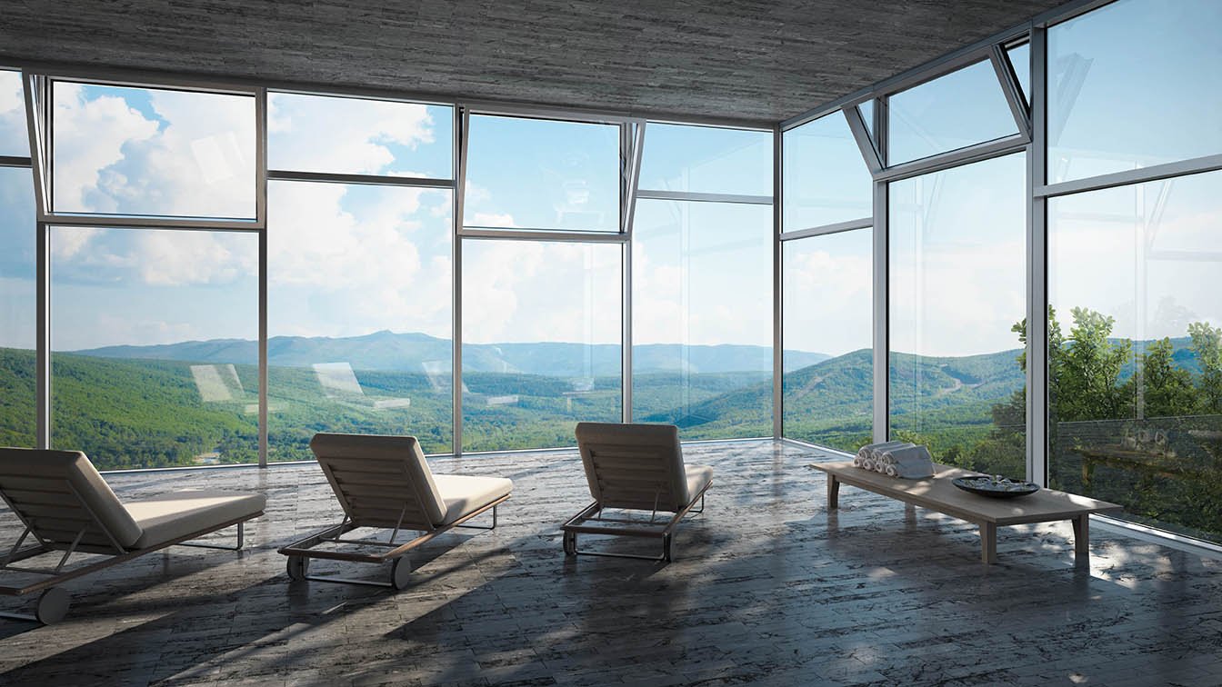 Utsikt over fjell gjennom glassfasade. 