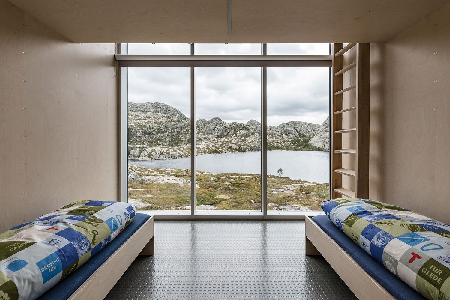 Soverom med utsikt gjennom store vinduer ut på fjellet